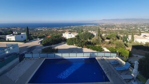 A swimming pool with a view of the sea and surrounding buildings. - Villa Imogine with Sea View (Neo Chorio)