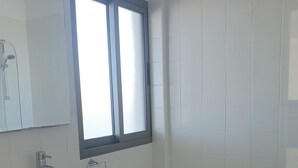 A bathroom with a sink, mirror, window, bathtub, and toilet. - Villa Imogine with Sea View (Neo Chorio)