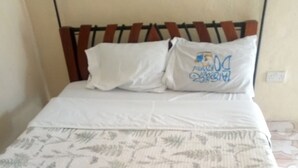 A bed with a patterned bedspread, two pillows, and a metal headboard. - Framjow Highway Lodge - Adults Only (Gilgil)