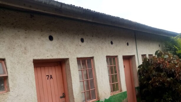 A building with a red door labeled "7A" and a window with a green and white painted wall. - Framjow Highway Lodge - Adults Only (Gilgil)