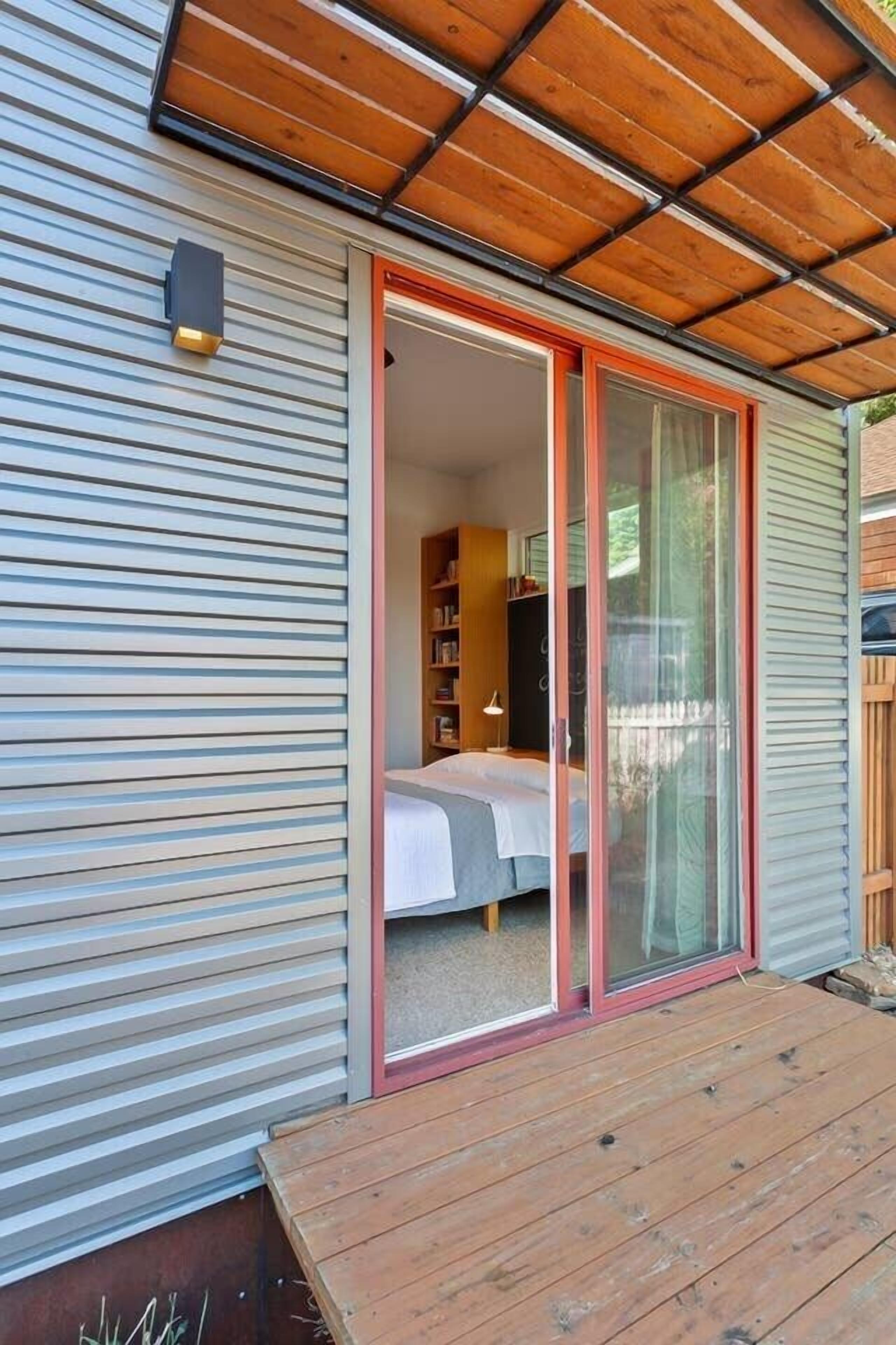 Une chambre moderne dotée d’une porte-fenêtre coulissante qui donne sur une chambre à coucher.