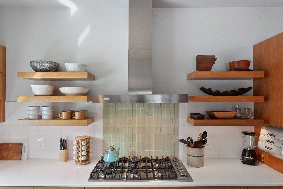 Een moderne keuken met houten planken, een gasfornuis en diverse keukengerei.