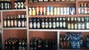 Un bar con estantes llenos de botellas de licores y cerveza.
