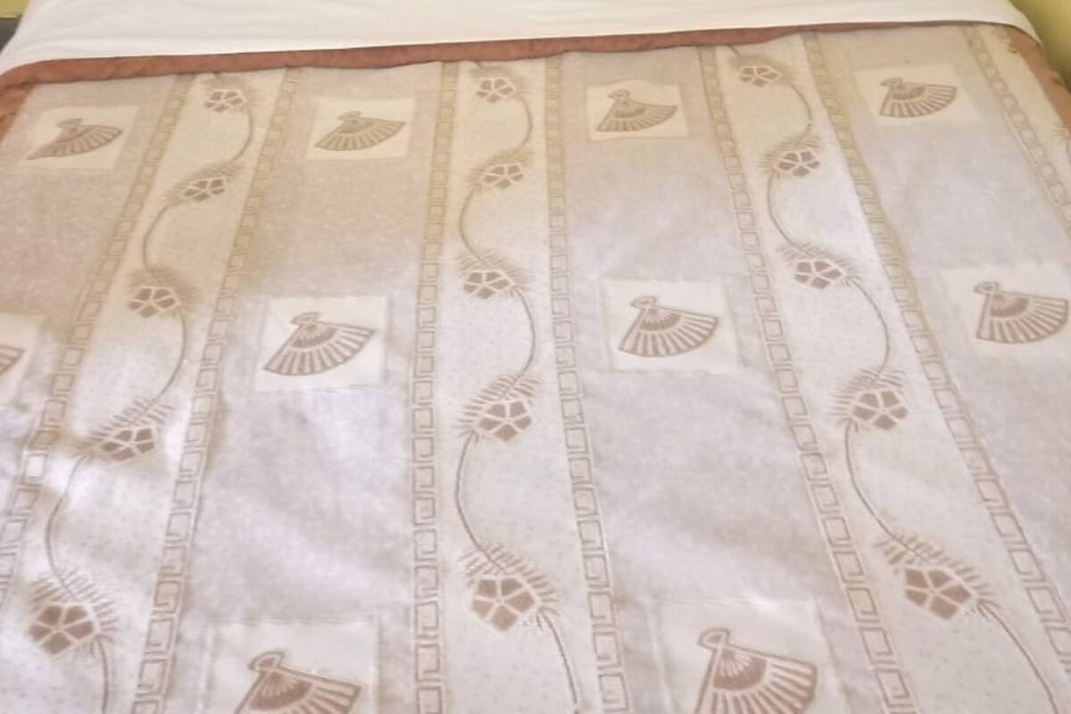 A bed with a wooden headboard and a patterned bedspread.