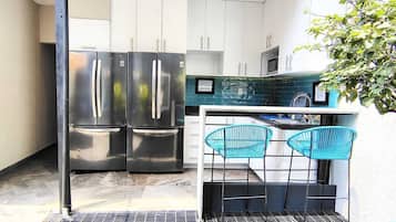 Een koelkast, een magnetron, kookgerei, borden en bestek