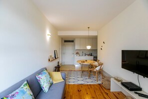 Un espace de vie compact comprenant un canapé, une table à manger et un téléviseur.