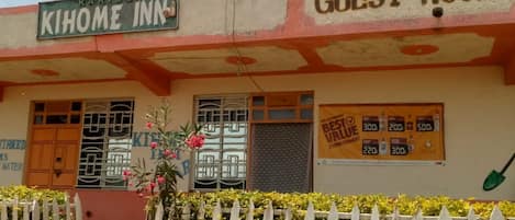 A building with a sign reading "Kihome Inn" and "Guest Rooms".