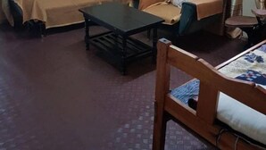 Ein Wohnzimmer mit einer Sofagarnitur, einem Couchtisch und einem gemusterten Teppich.