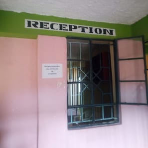 Una zona de recepción con un cartel que indica disponibilidad de habitaciones.