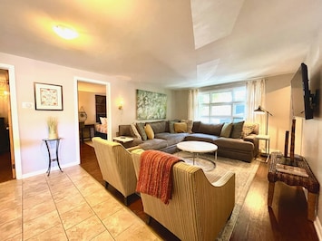 Beautiful and cozy open concept flat with large TV and loads of seating.