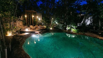 Una piscina al aire libre, sillones reclinables de piscina