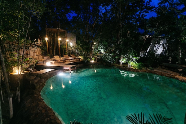 Una piscina al aire libre, sillones reclinables de piscina