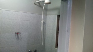 A small, enclosed shower area with a handheld showerhead and two control knobs. - Rainbow Guest House (Gilgil)