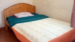 A small, single-bed room with a wooden headboard and a simple, clean design. - Rainbow Guest House (Gilgil)