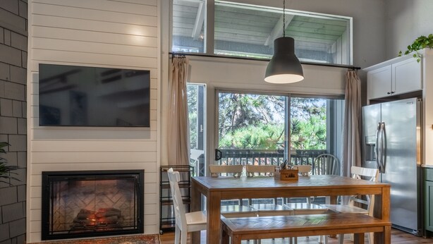 A modern kitchen with a large window, a dining table, and a built-in oven. - Sierra Park Villas #04 (Mammoth Lakes)