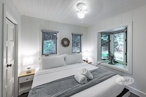 Relax in a serene bedroom with a large bed, two bedside tables, and a ceiling fan.