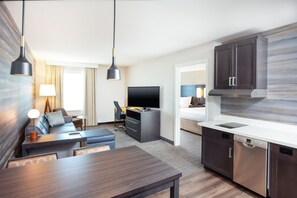 A modern hotel room with a dining area, kitchenette, and a TV. - Residence Inn by Marriott Livermore (Livermore)