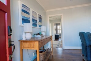 Enter a stylish living space with a console table, lamp, and artwork.