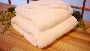 A stack of white towels with a label that reads "TOOTH BRUSH" on a wooden surface. - Kyomachiya near the World Heritage Toji (Toyodacho)