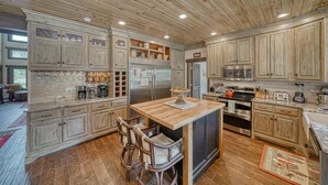 Une cuisine spacieuse avec des meubles en bois, un îlot central et des tabourets de bar.