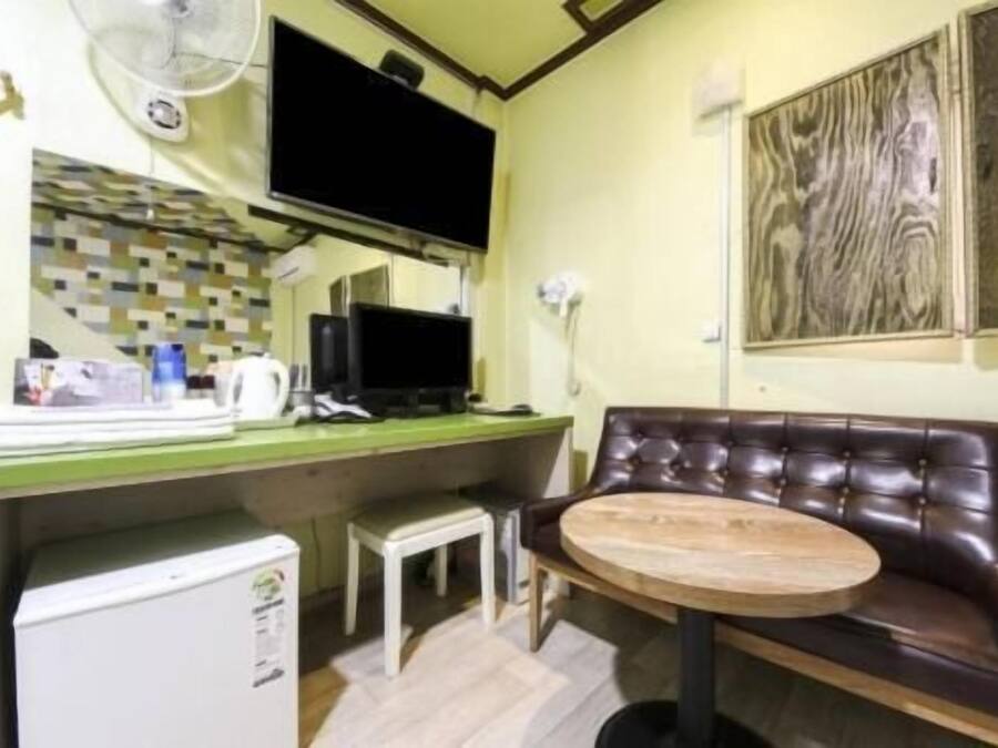 Une petite cuisine équipée comprenant un réfrigérateur, une petite table et une chaise.