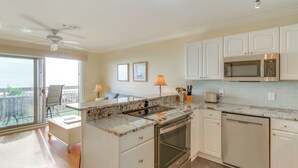 Una cucina moderna con pensili bianchi, forno integrato e microonde.