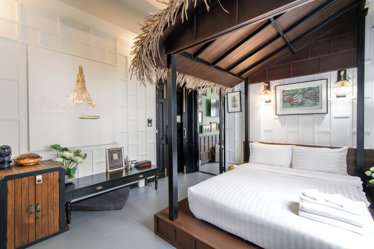 Una habitación de hotel moderna con una cama grande, un armario de madera, un espejo y un cuadro enmarcado en la pared.