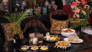 Una mesa de comedor con diferentes platos, un florero con flores y una silla decorativa.
