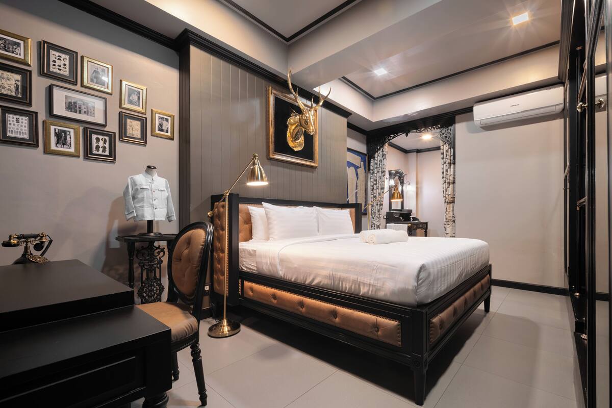 Un dormitorio moderno con una cama grande, un escritorio y un maniquí.