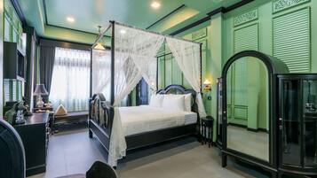 Quarto bem arrumado com cama de dossel, mesa de cabeceira, espelho e guarda-roupa.