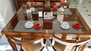 Una tavola imbandita con sottopiatti, tazze, piattini e un piccolo vassoio di pasticcini.