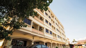 A multi-story hotel with balconies, a car parked in front, and a clear sky. - OYO 917 PK Residence Pattaya (Pattaya)