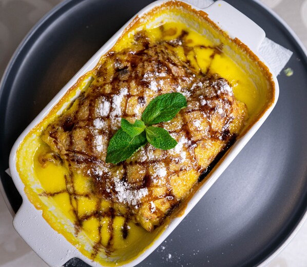 Uma sobremesa num prato branco sobre um prato escuro.