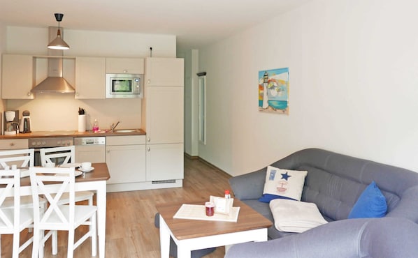 Un espace de vie compact comprenant un coin cuisine, un coin repas et un coin salon.