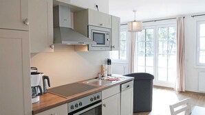 A modern kitchen with white cabinets, a microwave, a coffee maker, and a dishwasher. - Baabe Inselparadies Fewo Bernstein Ref. 213719 u 3 - Fewo Bernstein Ref. 213719 u 3 (Sellin)