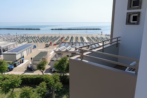 A beachside hotel with rows of beach chairs, a swimming pool, and a view of the ocean. - Hotel Concord (Ravenna)