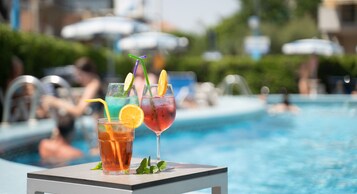 Una piscina al aire libre, sombrillas, tumbonas