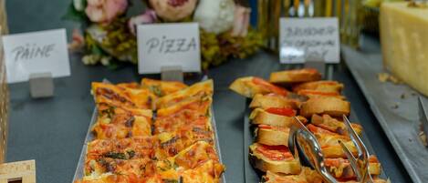 Un bufé con secciones identificadas para 'Pâine' y 'Pizza'.