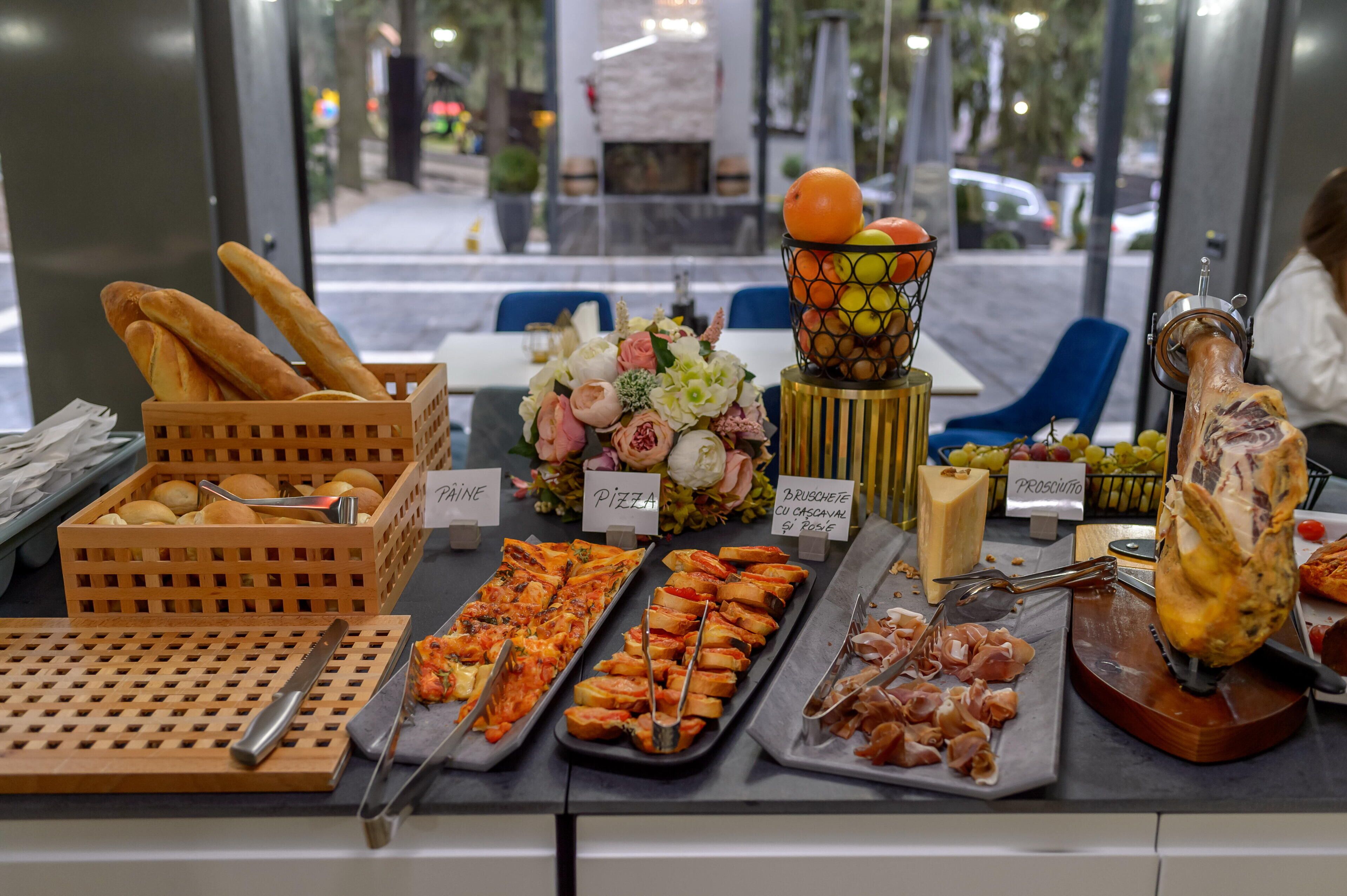 A buffet with various food items including bread, pizza, and meat.