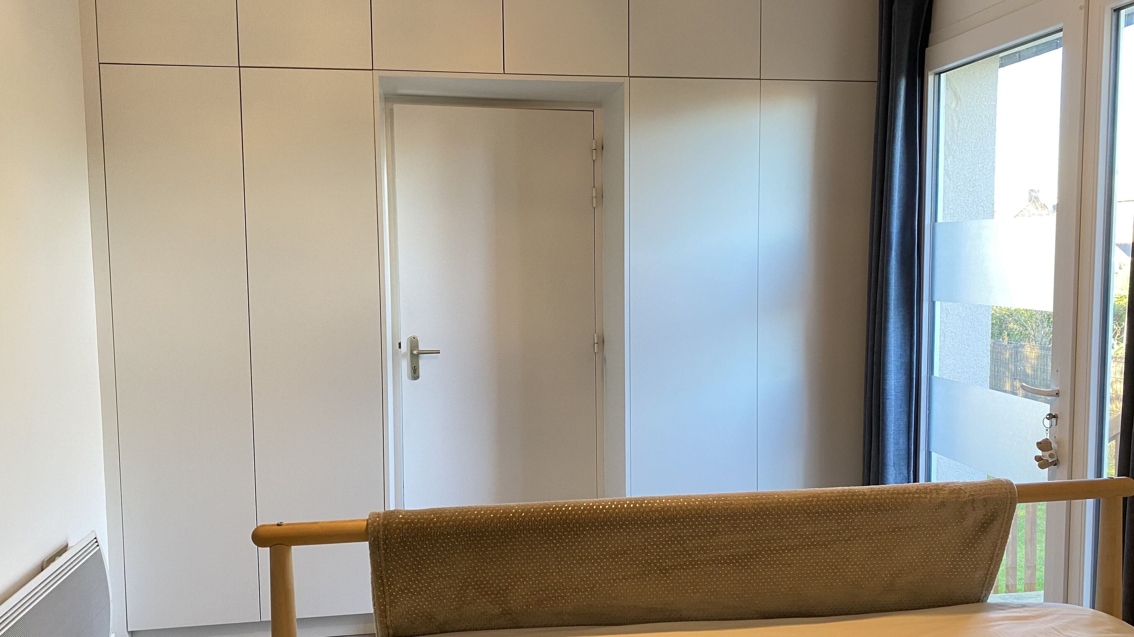 Une pièce comprenant un lit, une armoire et une porte.