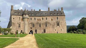 A large stone castle with a central tower, multiple windows, and a well-maintained lawn. - Appartements Résidence des 3 îles - Binic-Etables sur mer (Binic-Etables-sur-Mer)