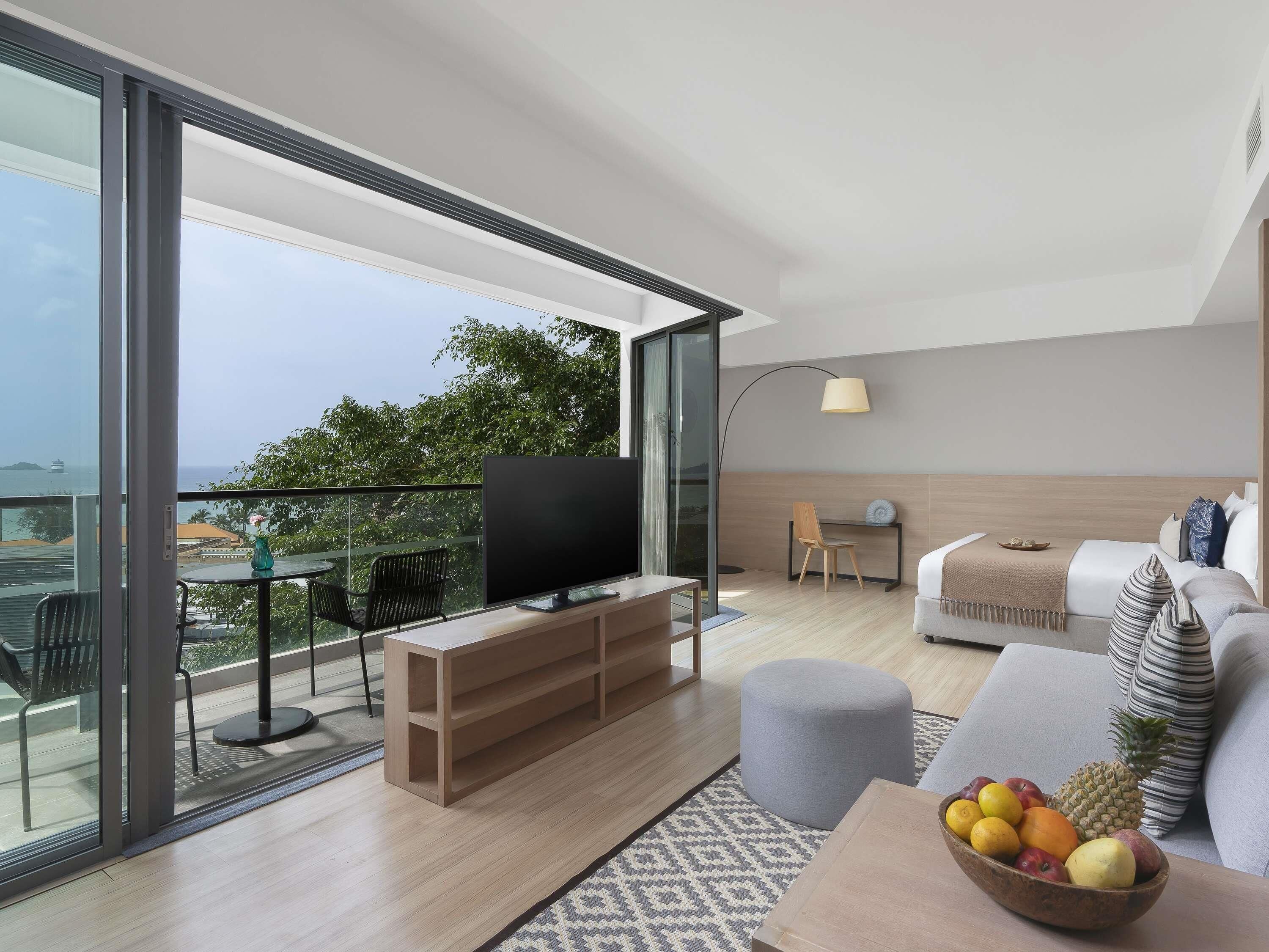 A modern living room with a TV, sofa, and a fruit bowl.