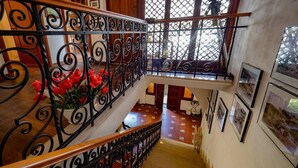 A staircase with ornate black metal railings and a wooden handrail, leading to a lower level. - Villa Tanca with Terrace and Views (Monterosso al Mare)