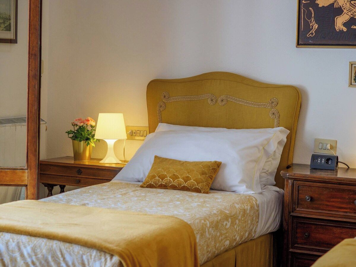 Ein Hotelzimmer mit einem Bett, Nachttischen, einer Lampe und einer wandmontierten Steckdose.