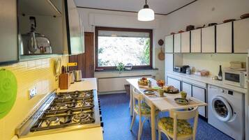 A compact kitchen with a gas stove, a microwave, and a washing machine.