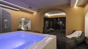 A modern spa room with a heated floor, seating area, and a large mirror. - Grand Hotel San Gemini | UNA Esperienze. (San Gemini)