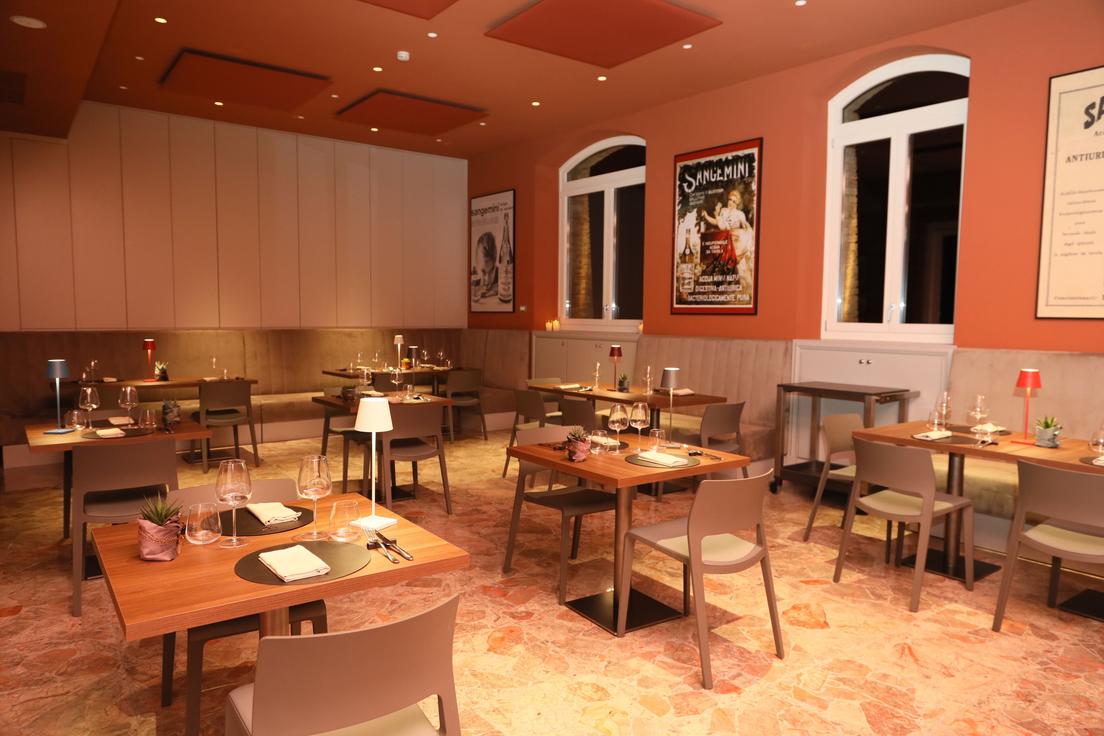 Un restaurant doté de nombreuses tables et chaises, disposées dans un espace vaste et aéré, avec de hauts plafonds et de grandes fenêtres.