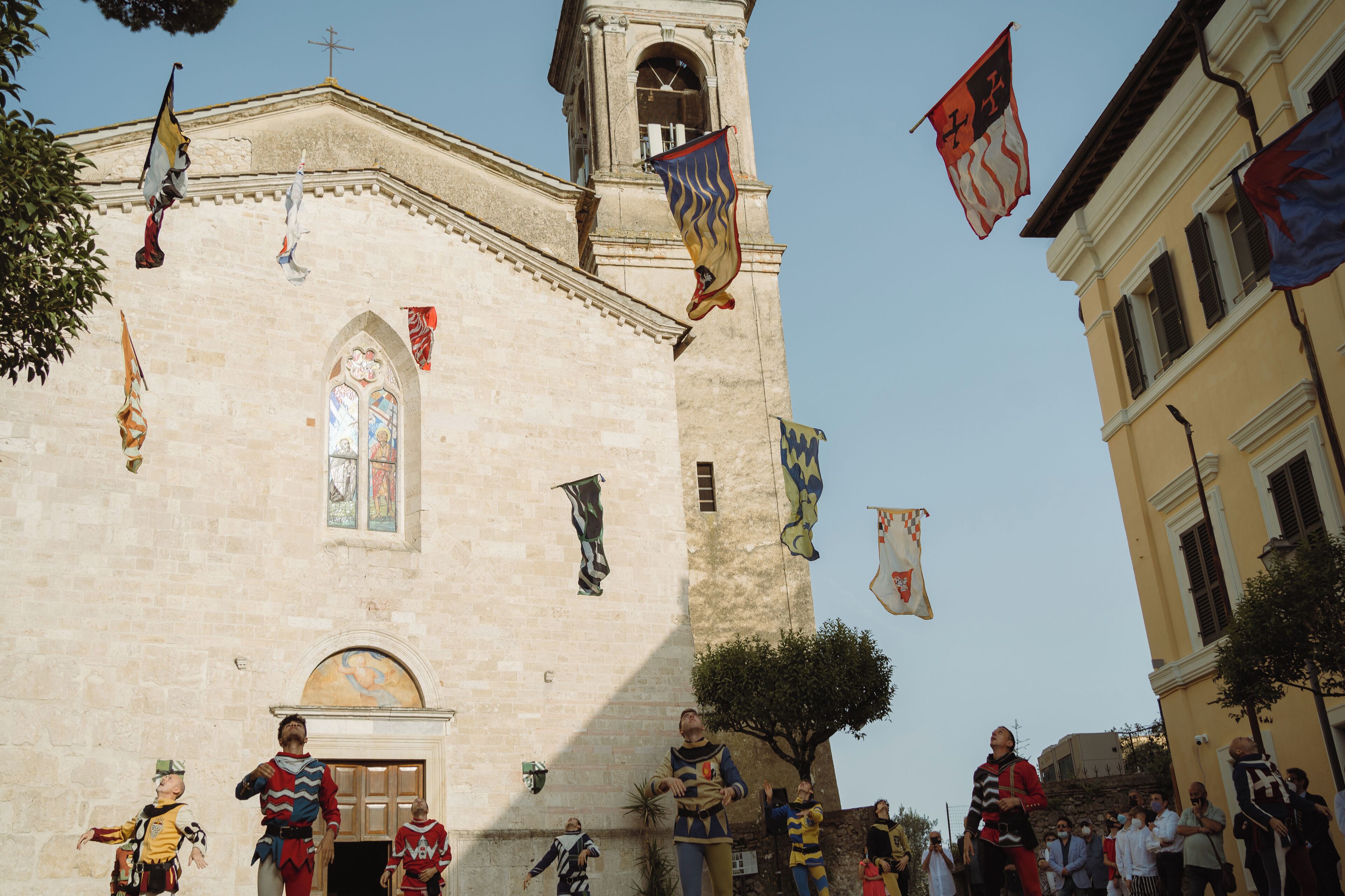 Un edificio storico con una torre dell'orologio, finestre ad arco e una campana.