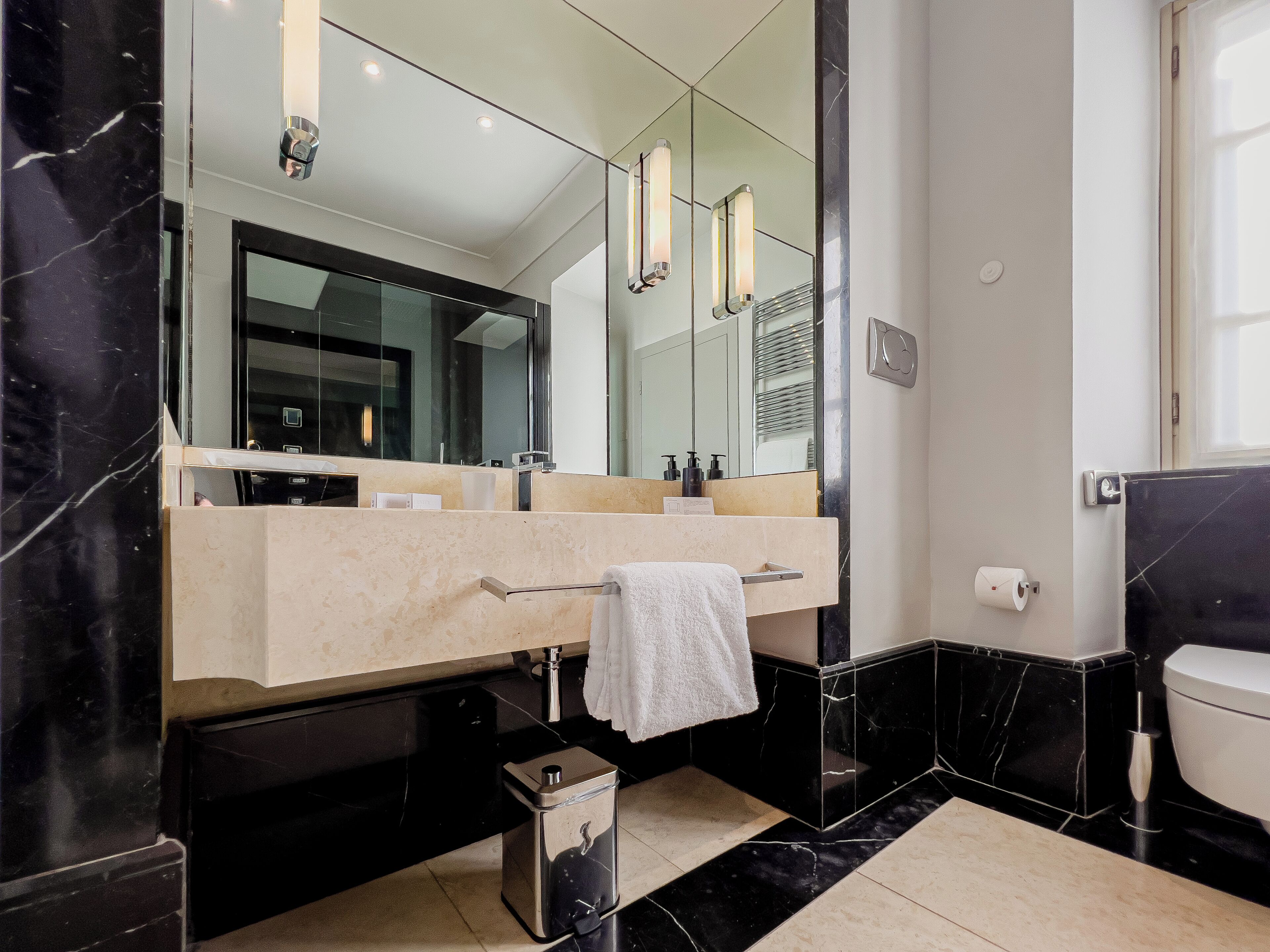 Un bagno moderno con uno specchio grande, un mobile lavabo e un portascopino.