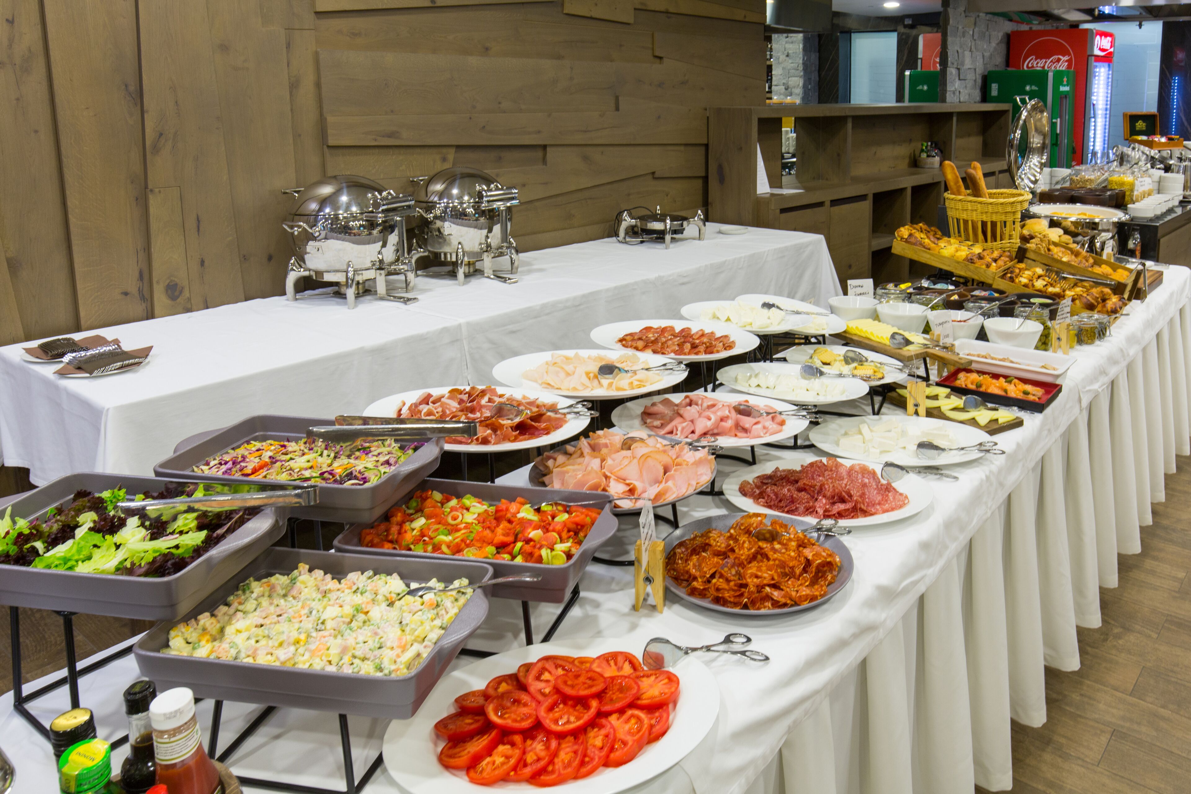 Una mesa de buffet con diversos alimentos y utensilios.